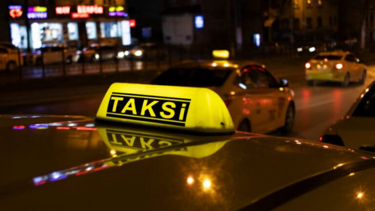 A taxi parked on the street, ready to transport passengers
